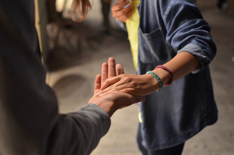 person reaching out and taking the hand,helping another person