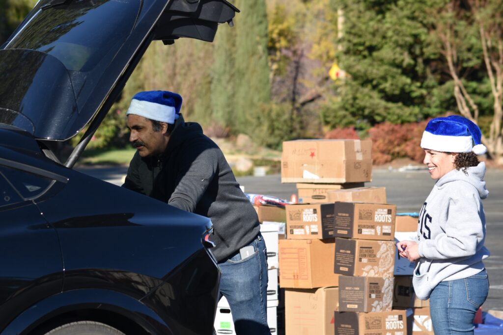 Volunteers placing gifts in a car