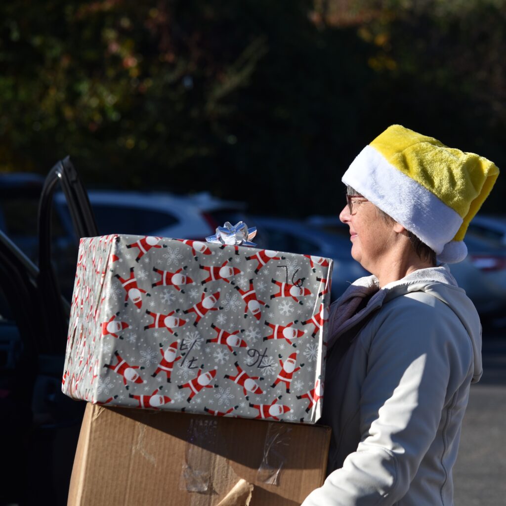 Volunteer carrying gift boxes